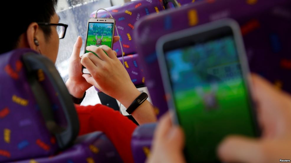 Pasajeron juegan "Pokemon Go" dentro de un autobús en Hong Kong, China, Aug. 12, 2016.