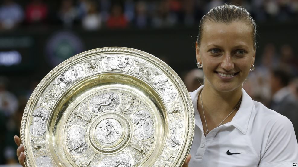 La campeona checa de tenis Petra Kvitova muestra el trofeo ganado en el torneo femenino de Wimbledon en 2014.