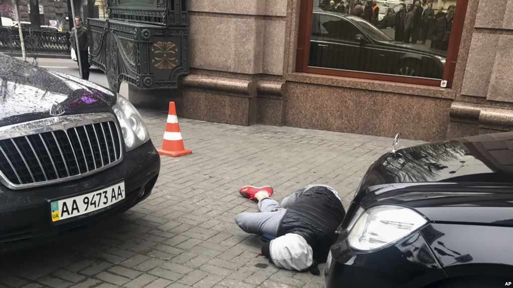 Un presunto asesino, que mató al ex legislador ruso Denis Voronenkov, yace herido en el suelo en una calle de Kiev, capital de Ucrania, el jueves 23 de marzo.