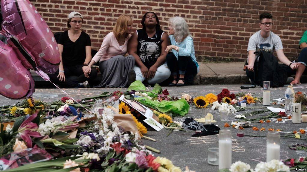 Mujeres se sentaron frente a un improvisado memorial en recuerdo de las vícitimas del ataque con un automóvil que tuvo lugar el 12 de agosto de 2017.
