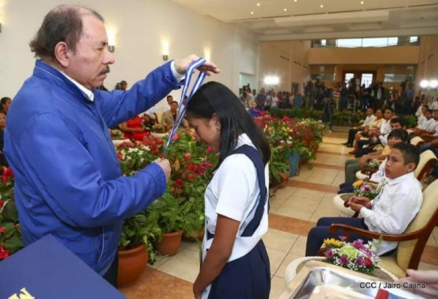 Ang-Chie Karina recibiendo reconocimiento de parte de Daniel Ortega