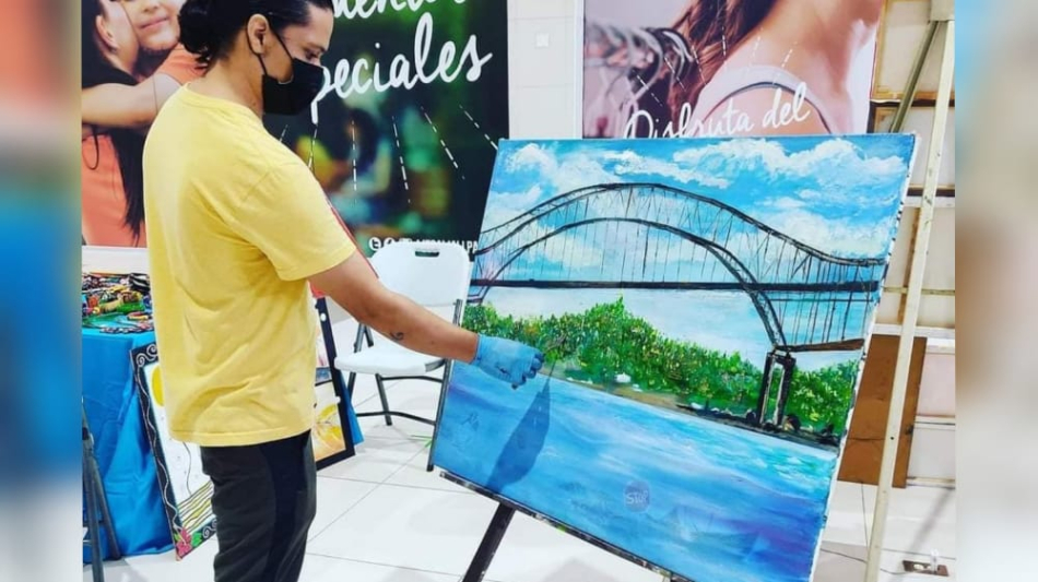 Israel Ramos, muestra una de sus más recientes pinturas, en el Palacio de Bellas Artes de Panamá.