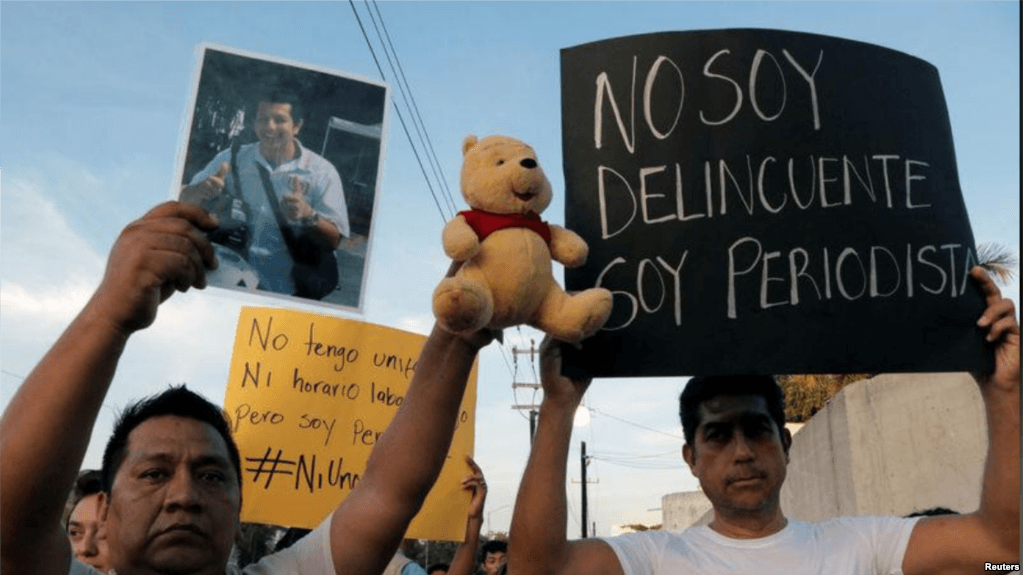 Imagen de archivo de personas sosteniendo fotos y carteles en una protesta por el asesinato del camarógrafo mexicano Javier Rodriguez Valladares, en Cancún, México, el 31 de agosto de 2018.